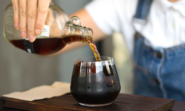 cold brew coffee being poured into a glass